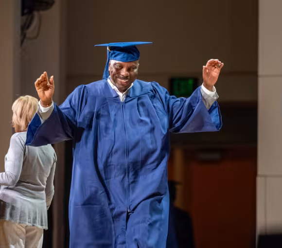 Graduate celebrates while walking on stage