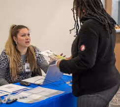 Photo of a Summit healthcare student talking with an employer from Health Partners at a hiring fair event