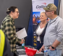 Electrician student speaking with employers from Collins at a hiring fair at Summit Academy OIC