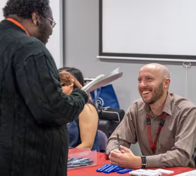 Employer partner speaking with a Summit student at a hiring fair event