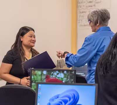 open house attendee speaking with a staff person at Summit Academy OIC