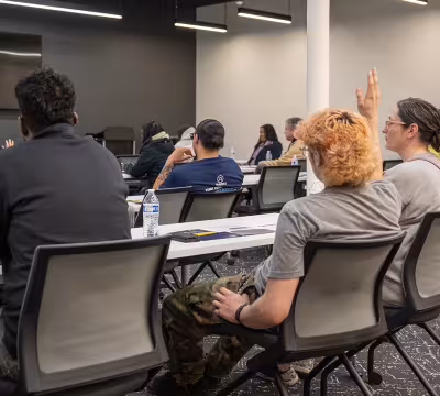 Prospective students listening and raising hands to ask questions at Summit Academy OIC's information session