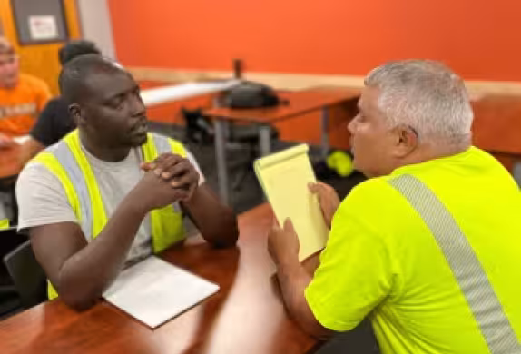 two construction students at Summit sitting at a table, one is black and one is white