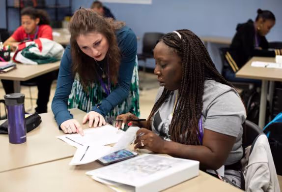 teacher and student working at a desk