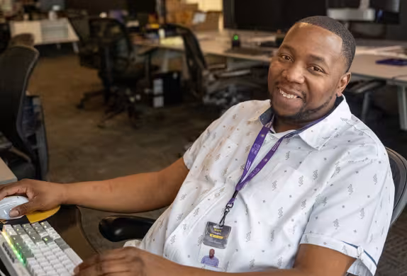 Photo of Marcus, Summit Academy graduate, at his desk at Atomic Data.