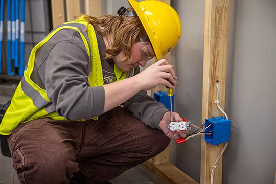 Electrician student installing an outlet