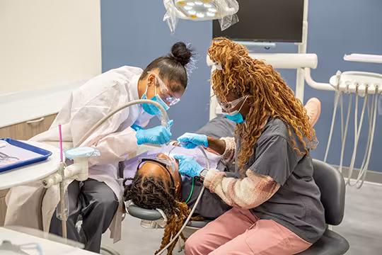 Unlicensed Dental Assistant students learning hands-on in exam room at Summit