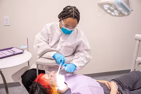 Unlicensed Dental Assistant students learning hands-on in exam room at Summit