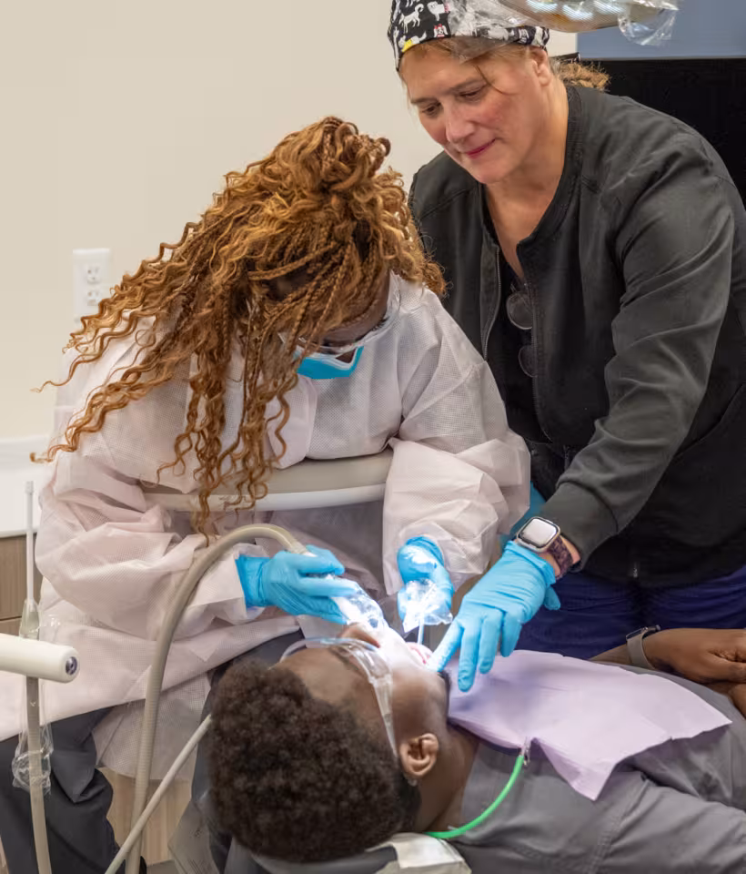 dental assistant instructor supervising student in exam room