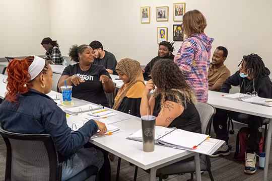 GED students and instructor discussing a group activity in class