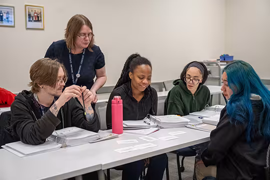 GED students and instructor discussing a group activity in class