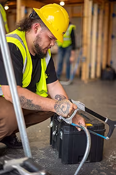 Electrician student sawing a pipe