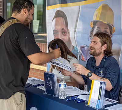Summit staff checking in a prospective student at an enrollment open house event