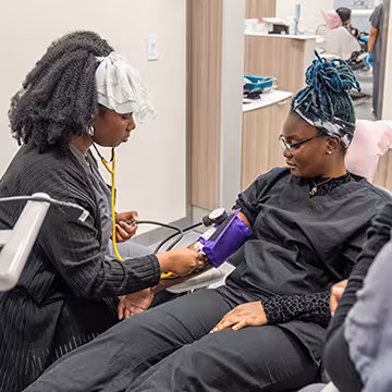 Unlicensed Dental Assistant students learning hands-on in exam room at Summit