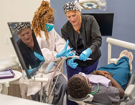 Unlicensed Dental Assistant students learning hands-on in exam room at Summit
