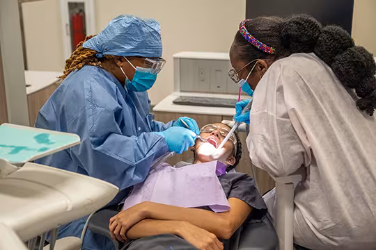 Unlicensed Dental Assistant students learning hands-on in exam room at Summit