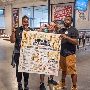 Summit employees at Fowling Warehouse holding bracket sign after winning