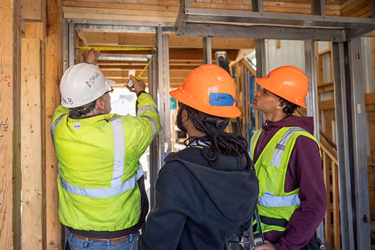 Carpentry students at Summit observing instructor demonstrate the proper way to use a tape measure
