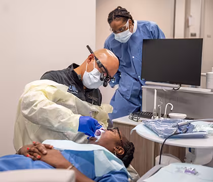 Unlicensed Dental Assistant student observing Pop Up Smiles dentist in Summit Academy's exam room