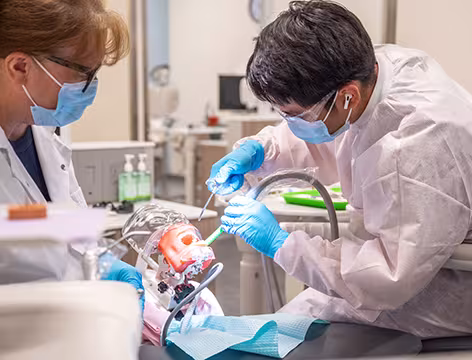 Unlicensed Dental Assistant student and instructor in exam room